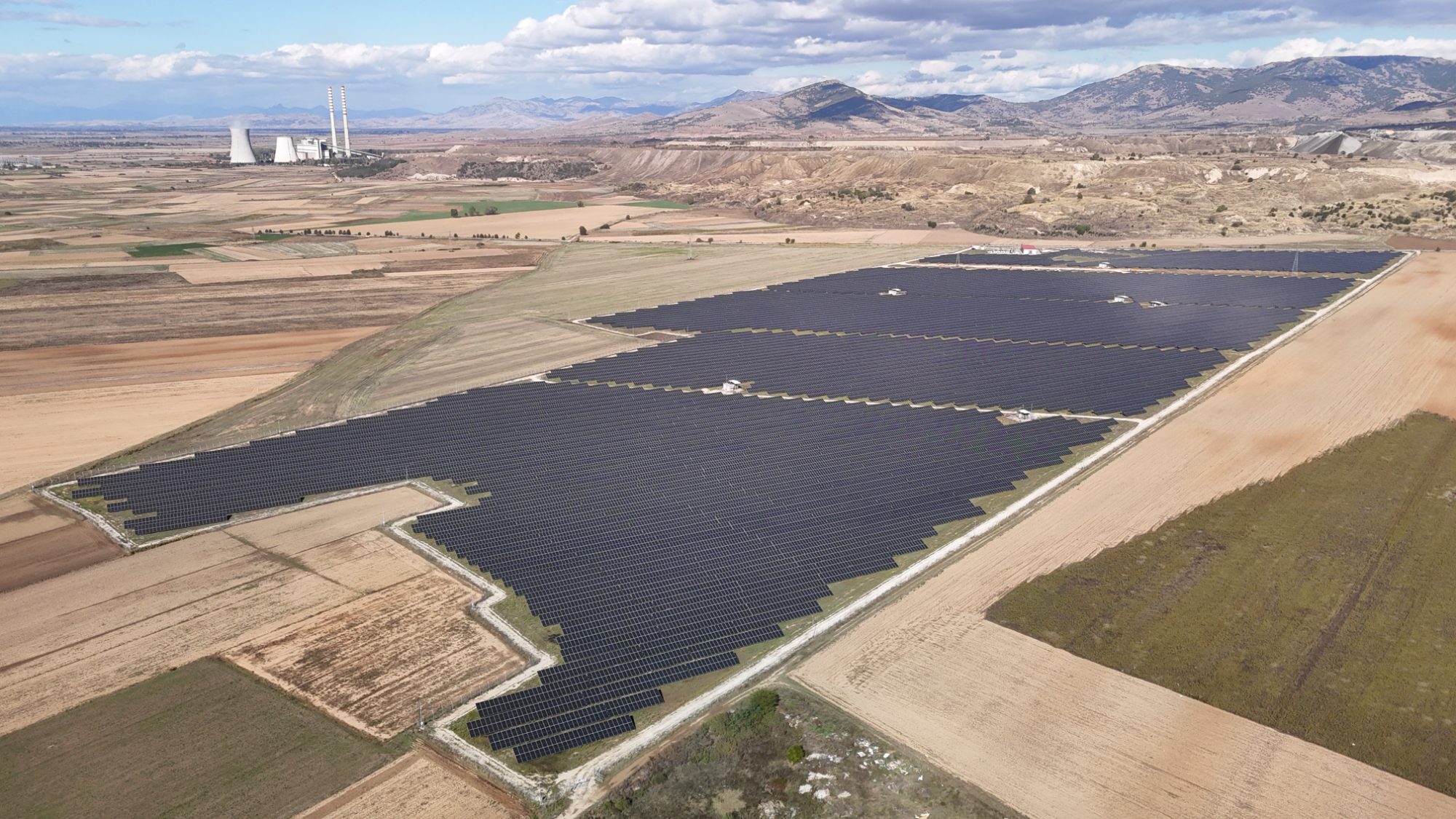 Aerial view of the MEY Energy solar plant in Novaci Municipality, with the Bitola lignite power station on the horizon